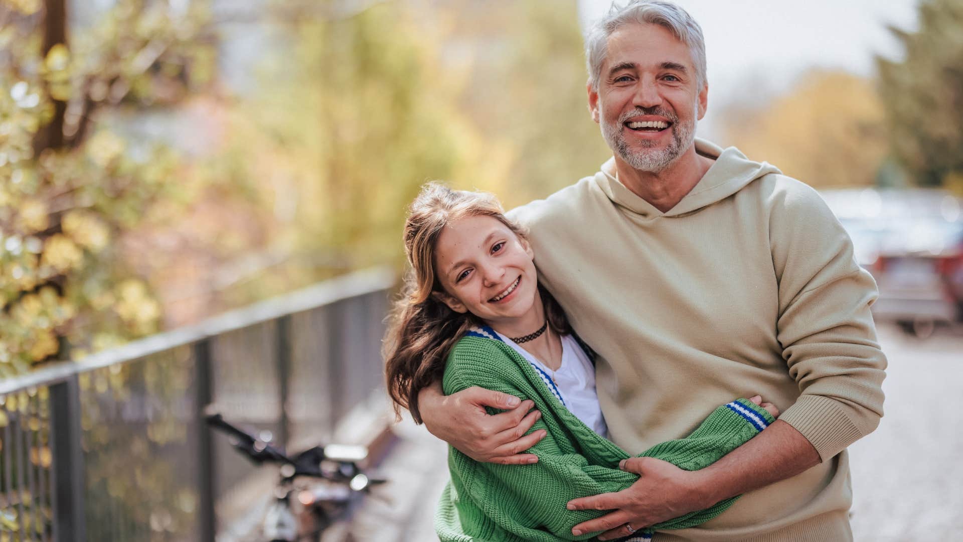 dad hugging daughter sharing his interests of bike riding with her