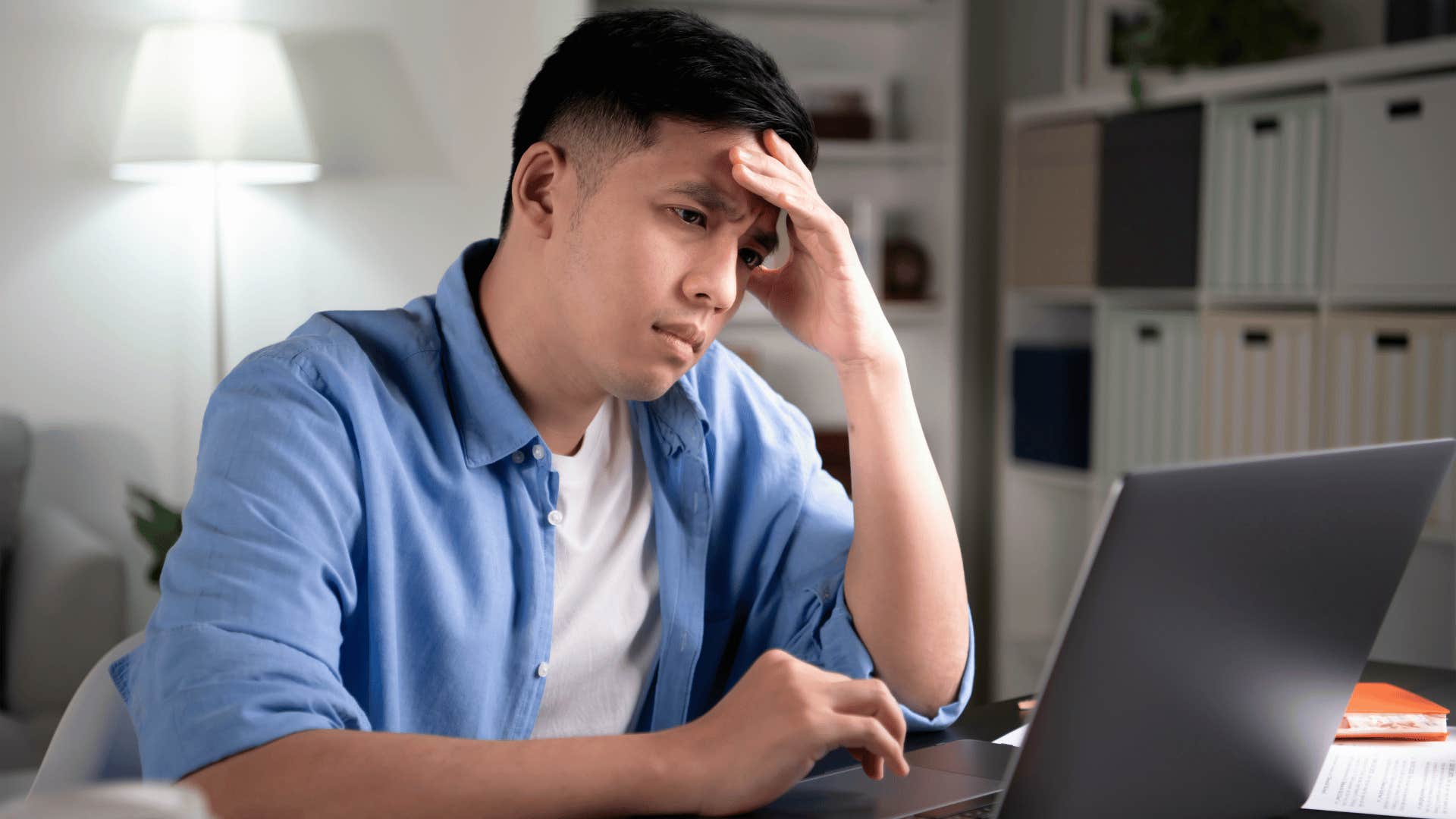 man lacking flexibility works hard as he stares at laptop upset