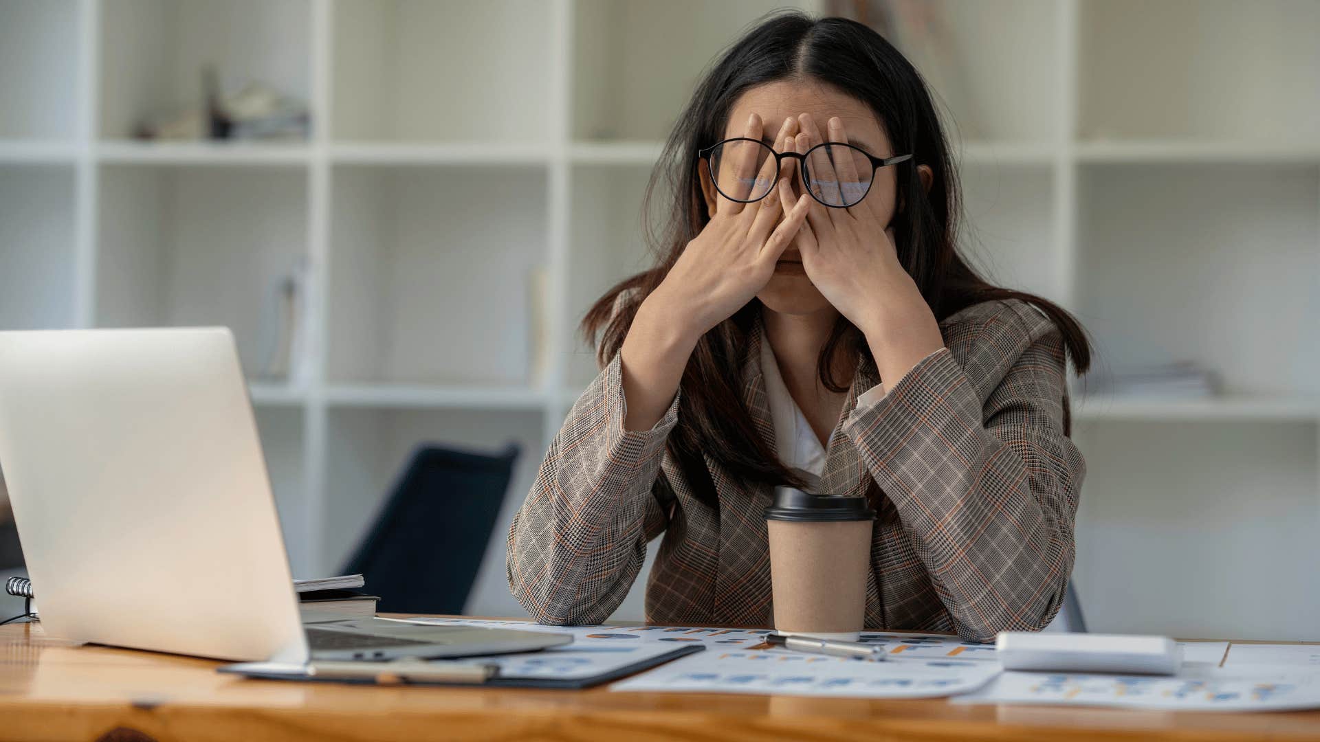 woman tired and rubbing face as she lacks work life balance 