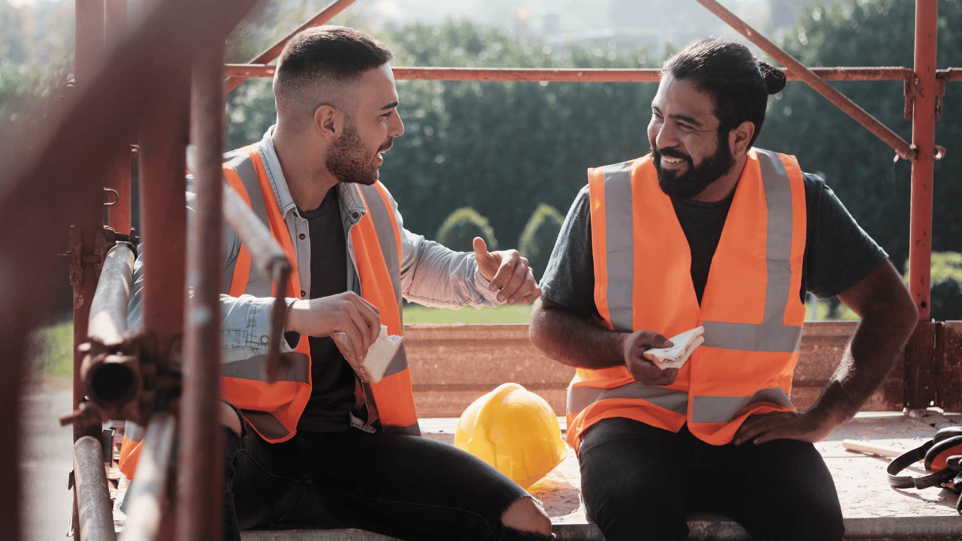 two construction workers sitting down and taking a short lunch break