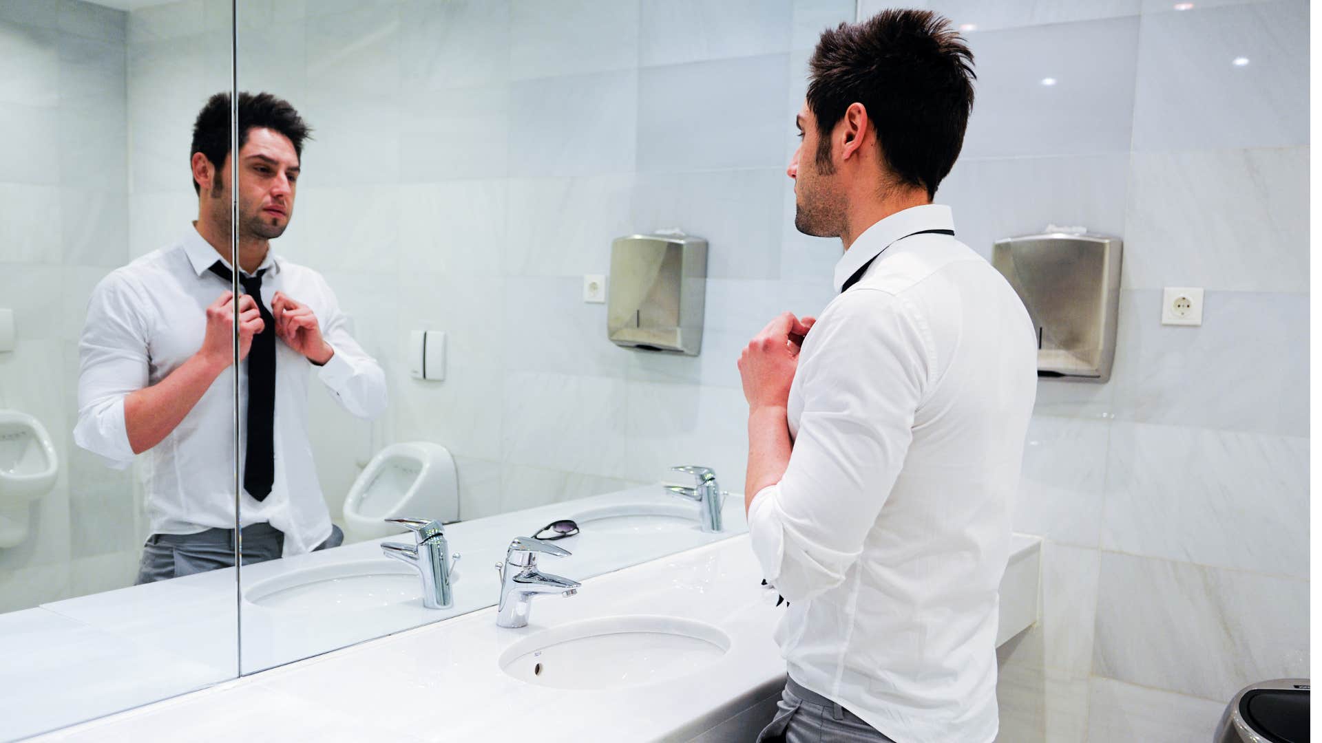 exhausted man looking in mirror after finding hair in the drain