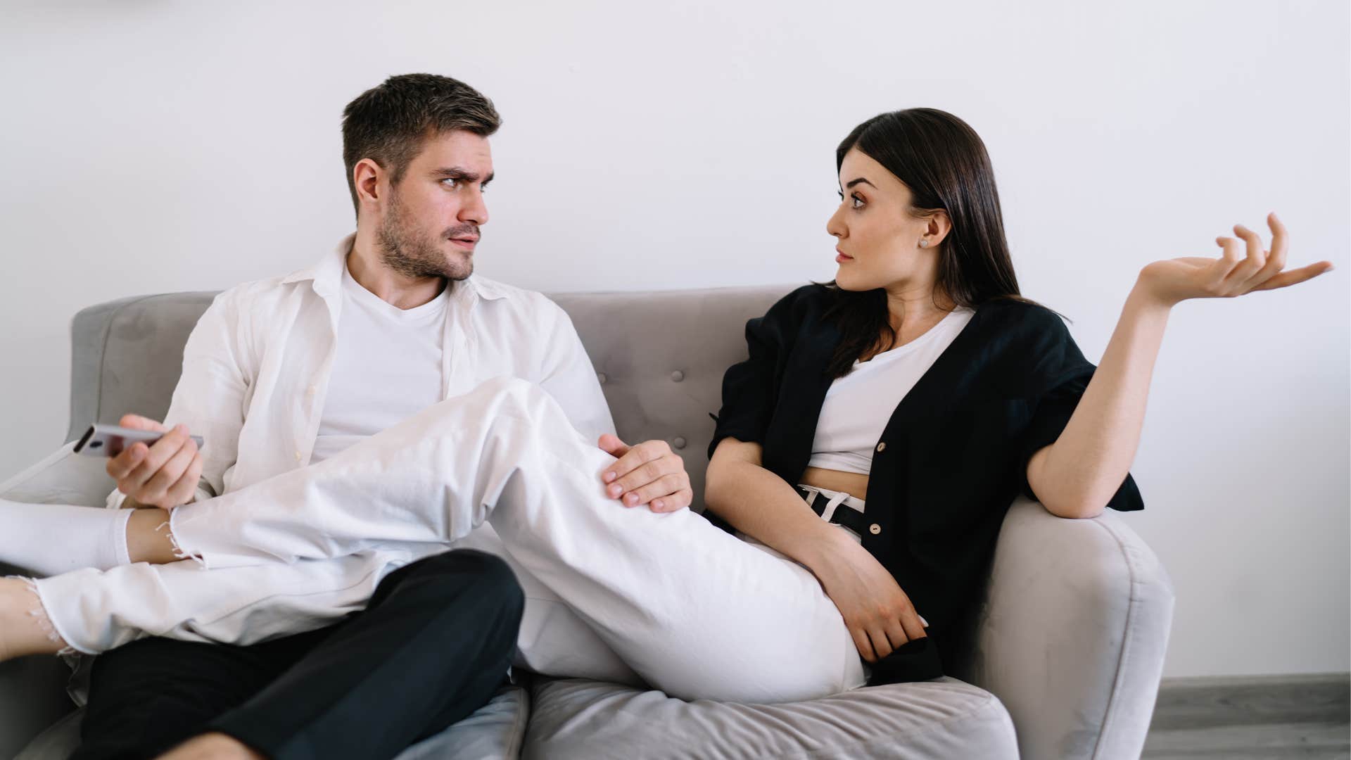 woman talking to husband trying to watch television