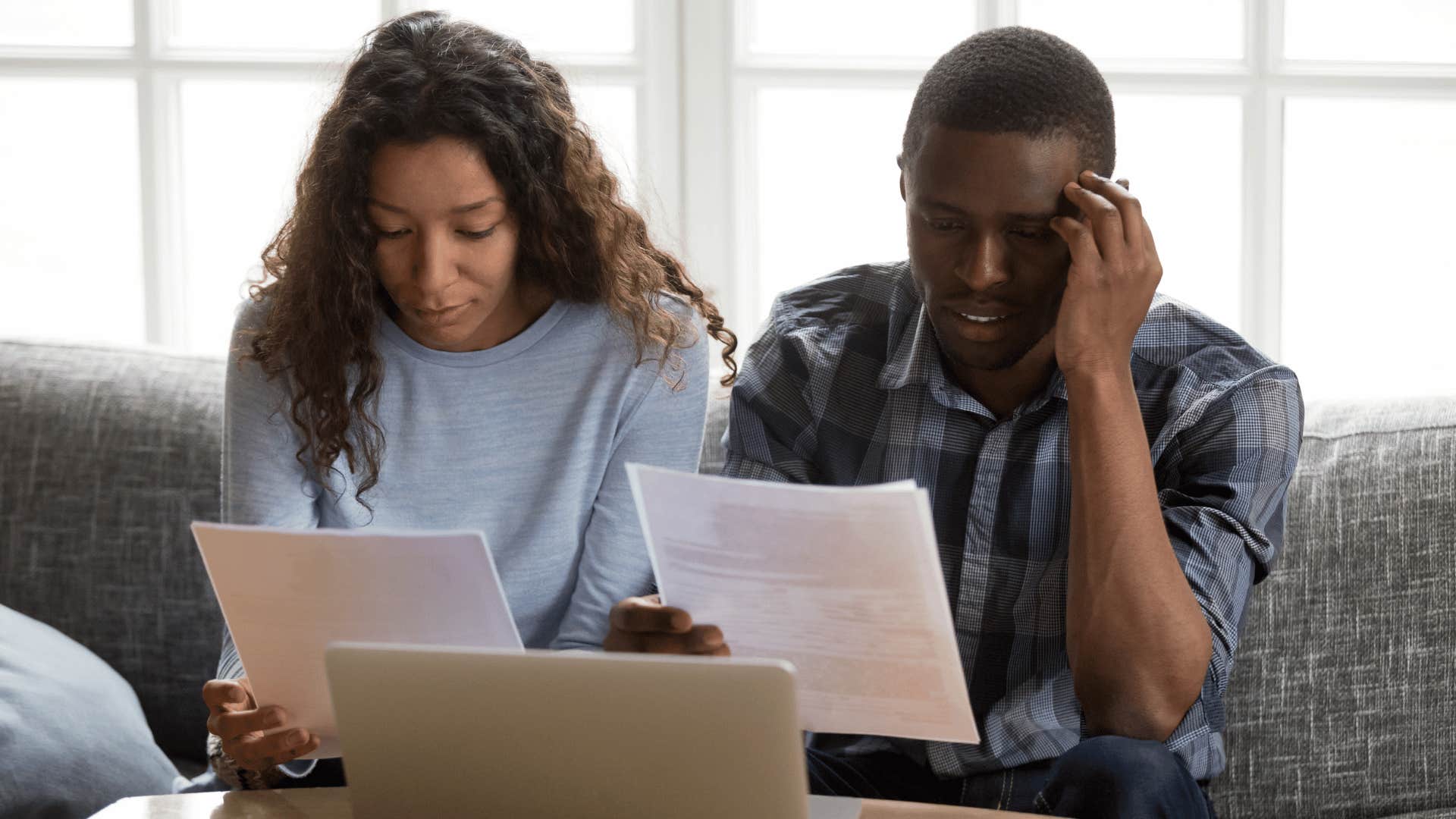 upset couple looking at late fee bills