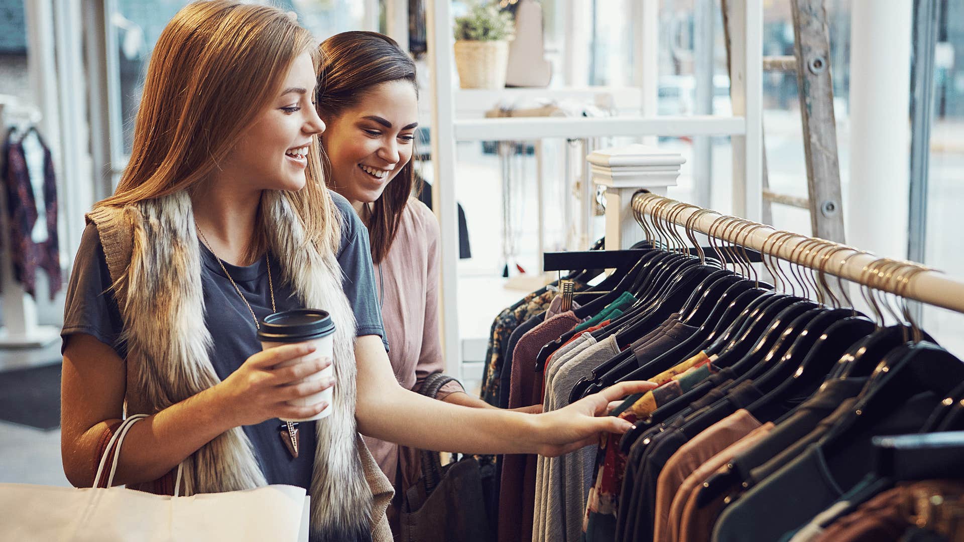 two young girls shopping for clothes for status