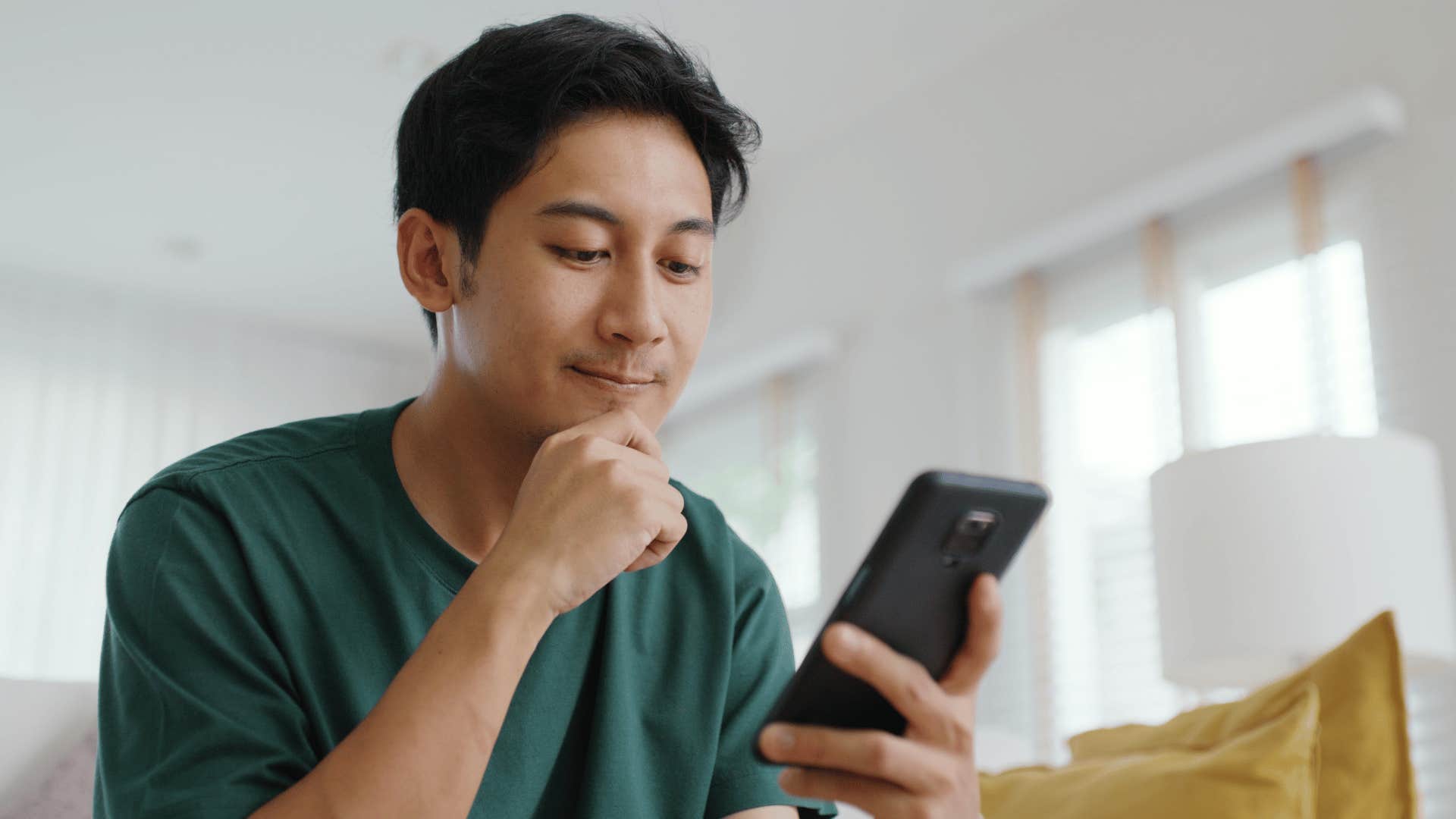 man smirking looking at his phone