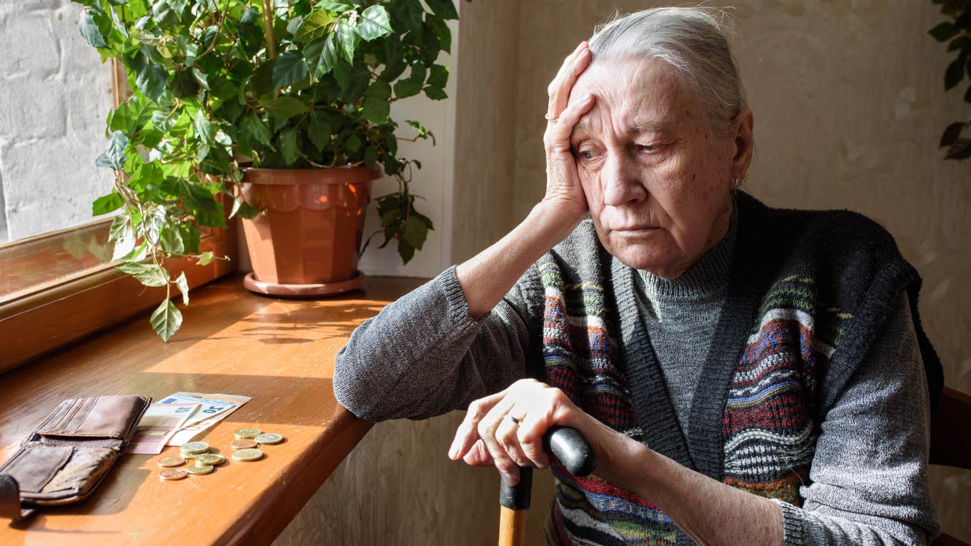broke and upset woman looking at money in her home