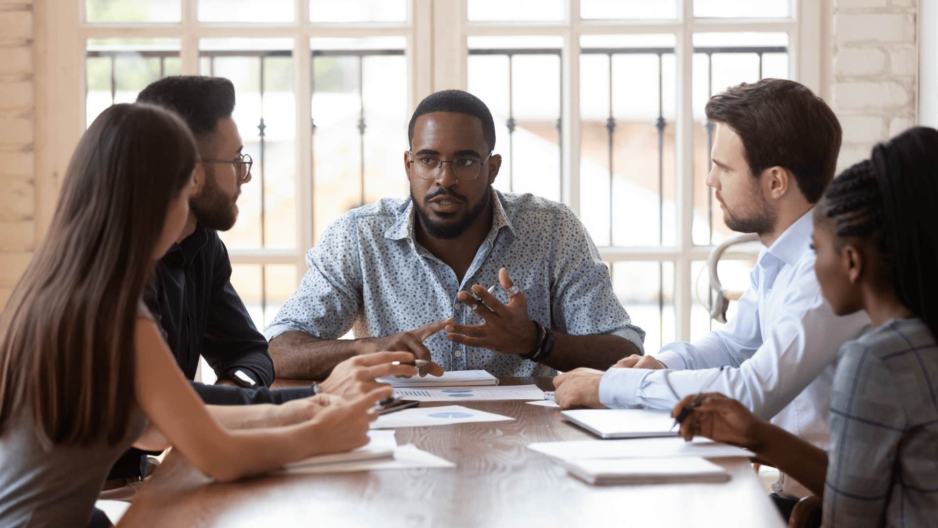 millennial boss talking to workers about the work week