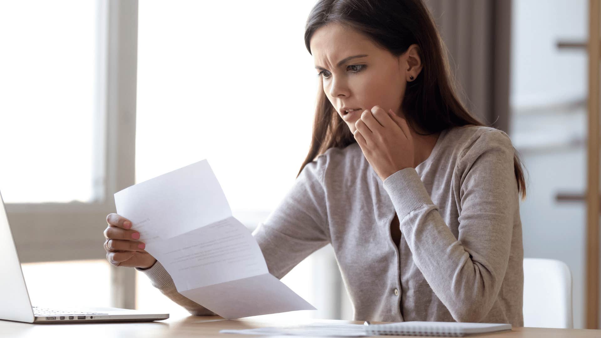 millennial woman looking at student loans she owes