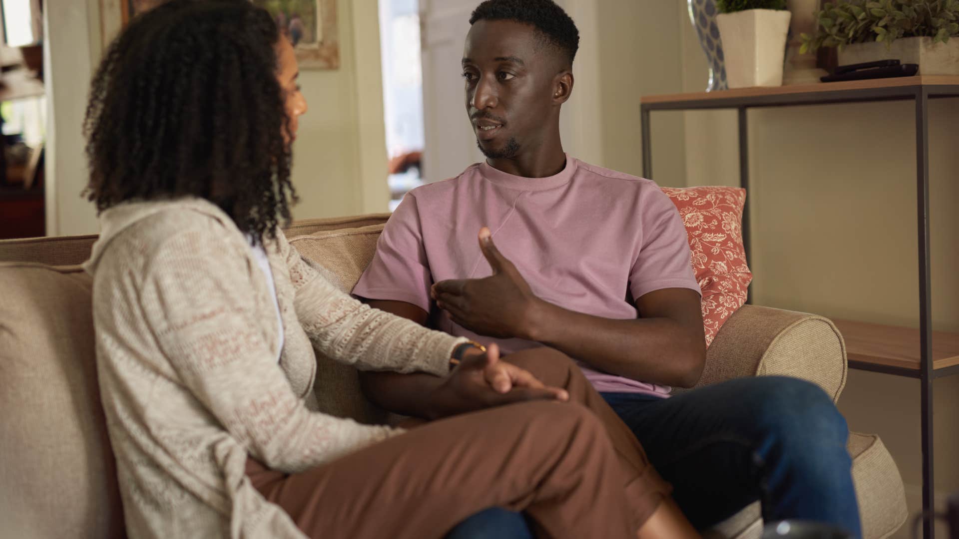 man speaking to partner on couch letting her be independent