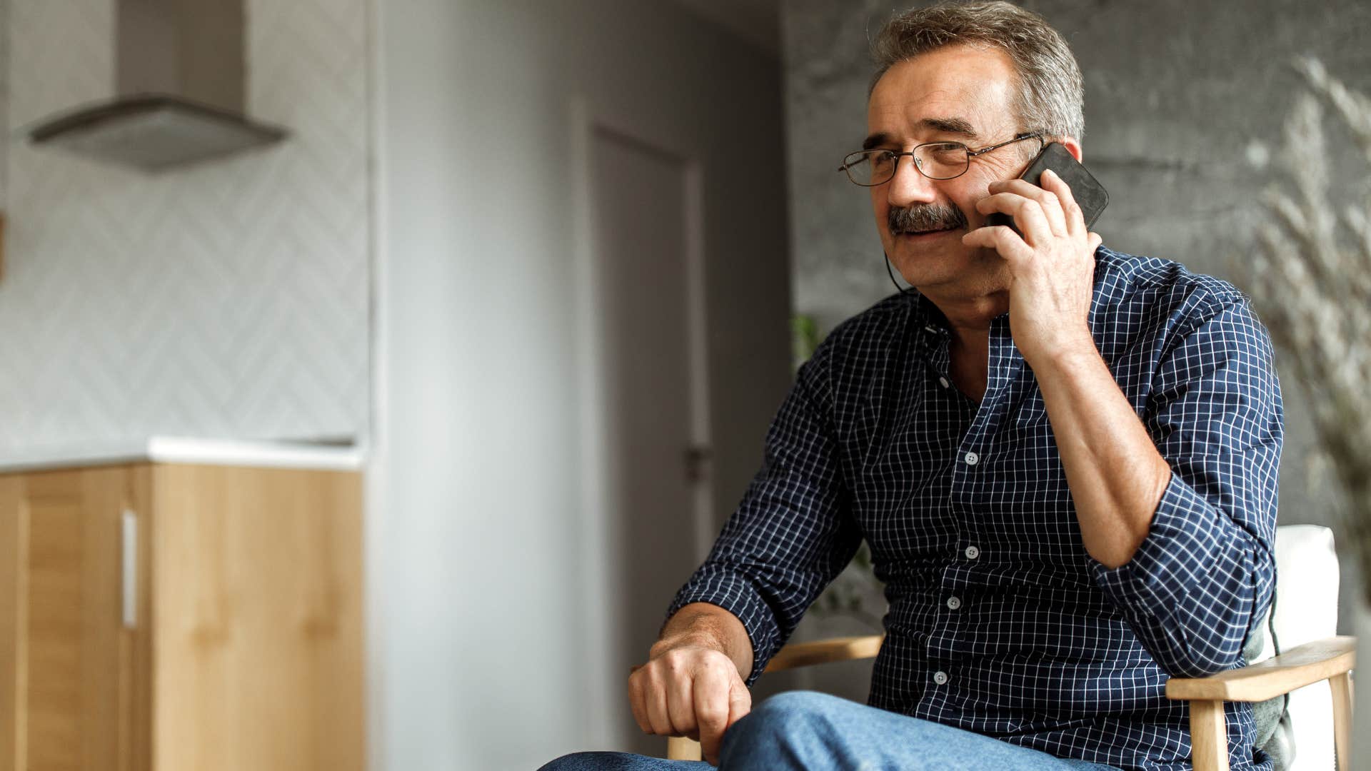 boomer man sitting in chai calling instead of texting