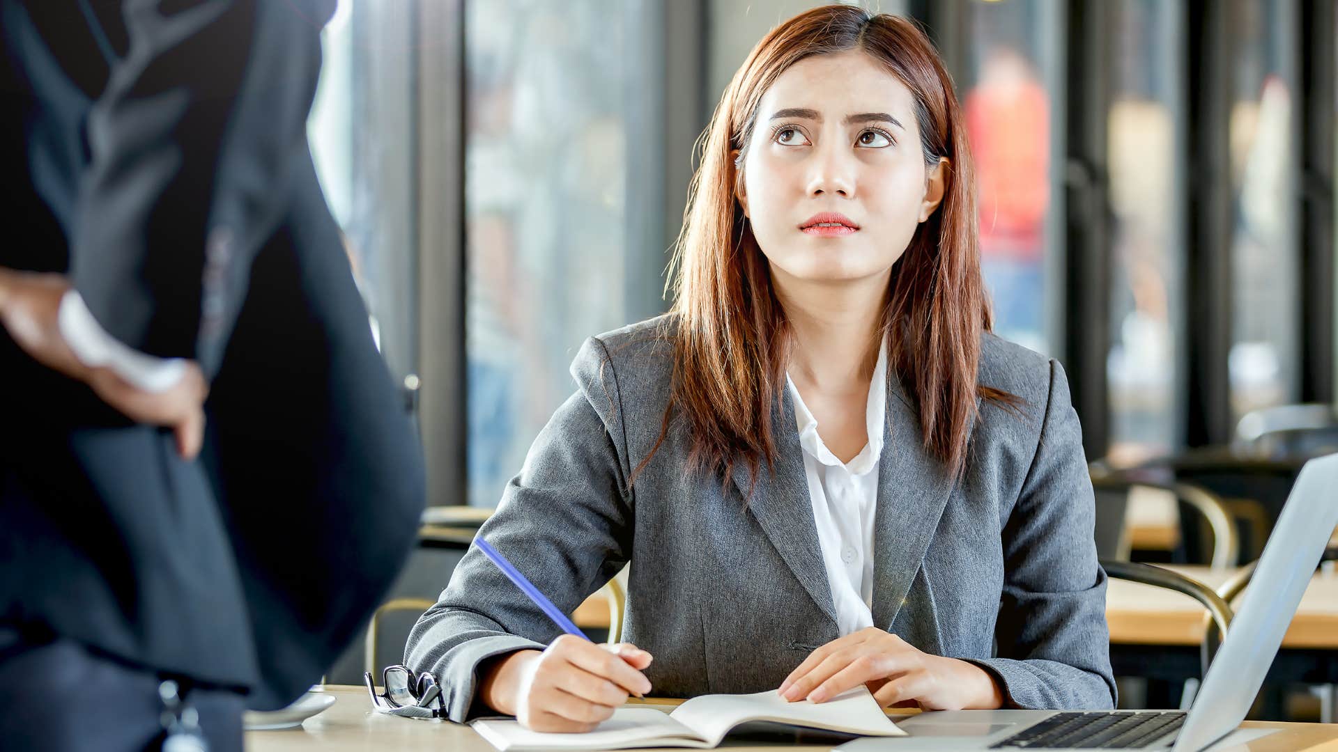 gen z worker looking annoyed with boss overstepping her work boundaries