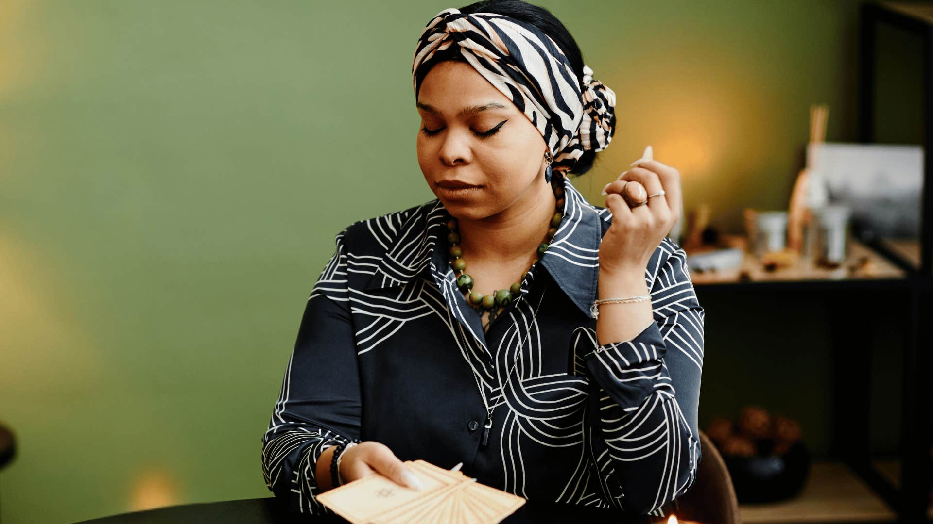 woman with psychic powers sitting at a table with her eyes closed