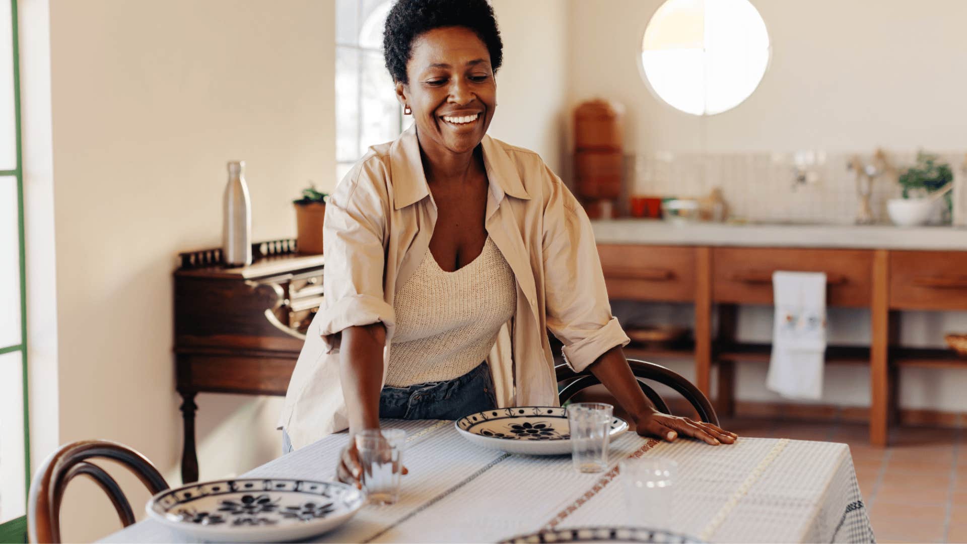 A woman places her matching dinnerware set on a table.