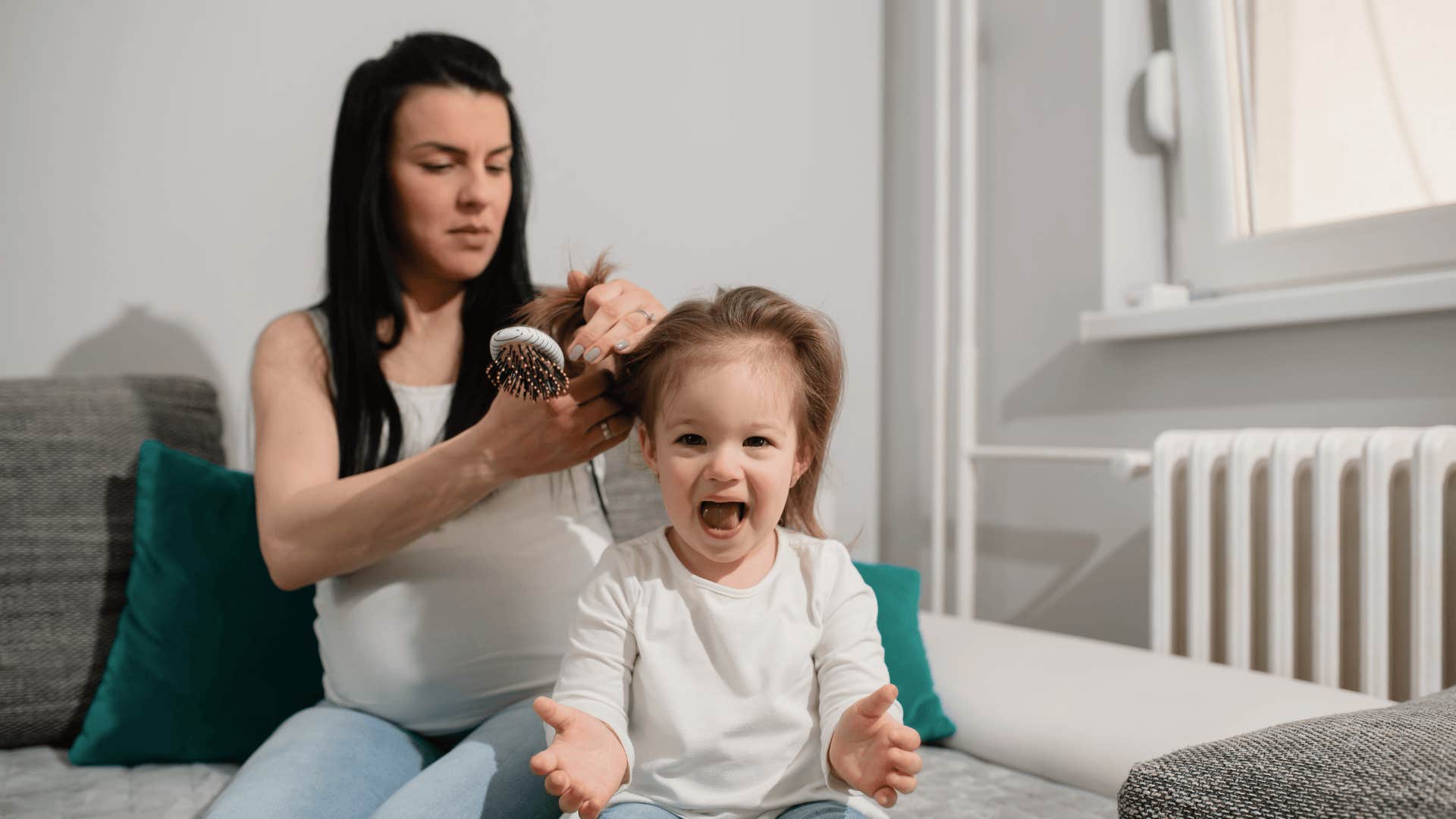 well-meaning mother combing daughter's hair