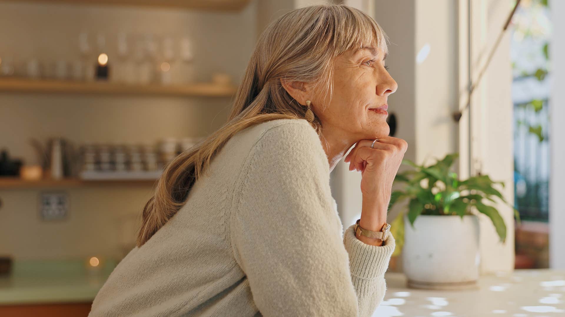 Woman who moves on quietly looking happily out a window.