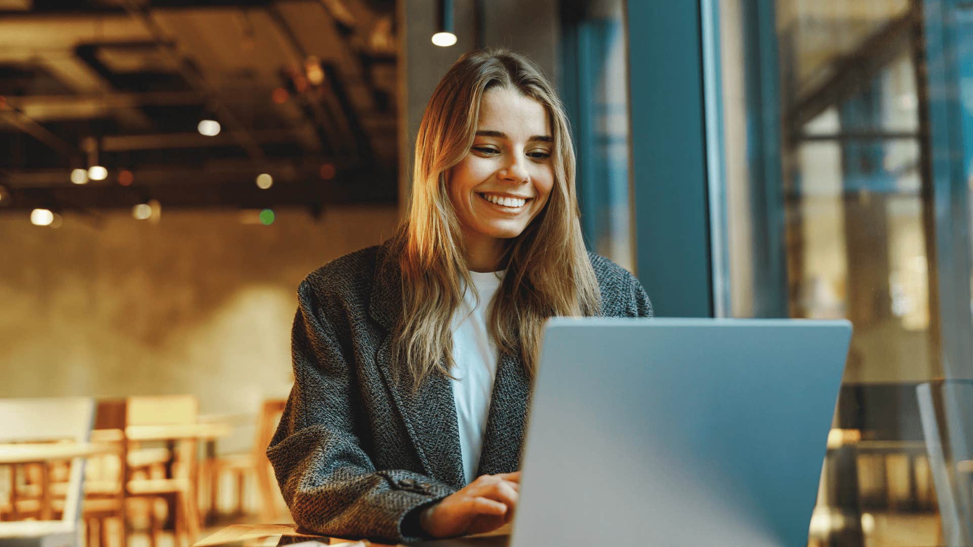 smiling woman in cafe who has traits to snag the best husband