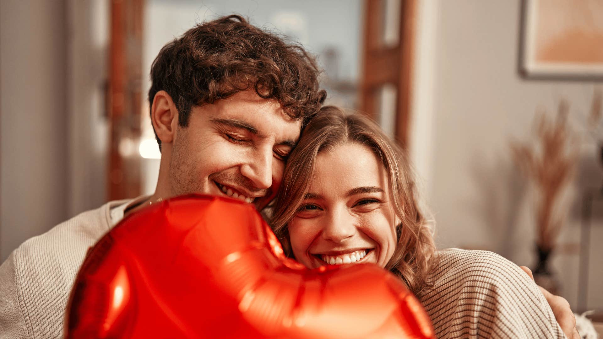 smiling woman holding heart balloon who snagged the best husband