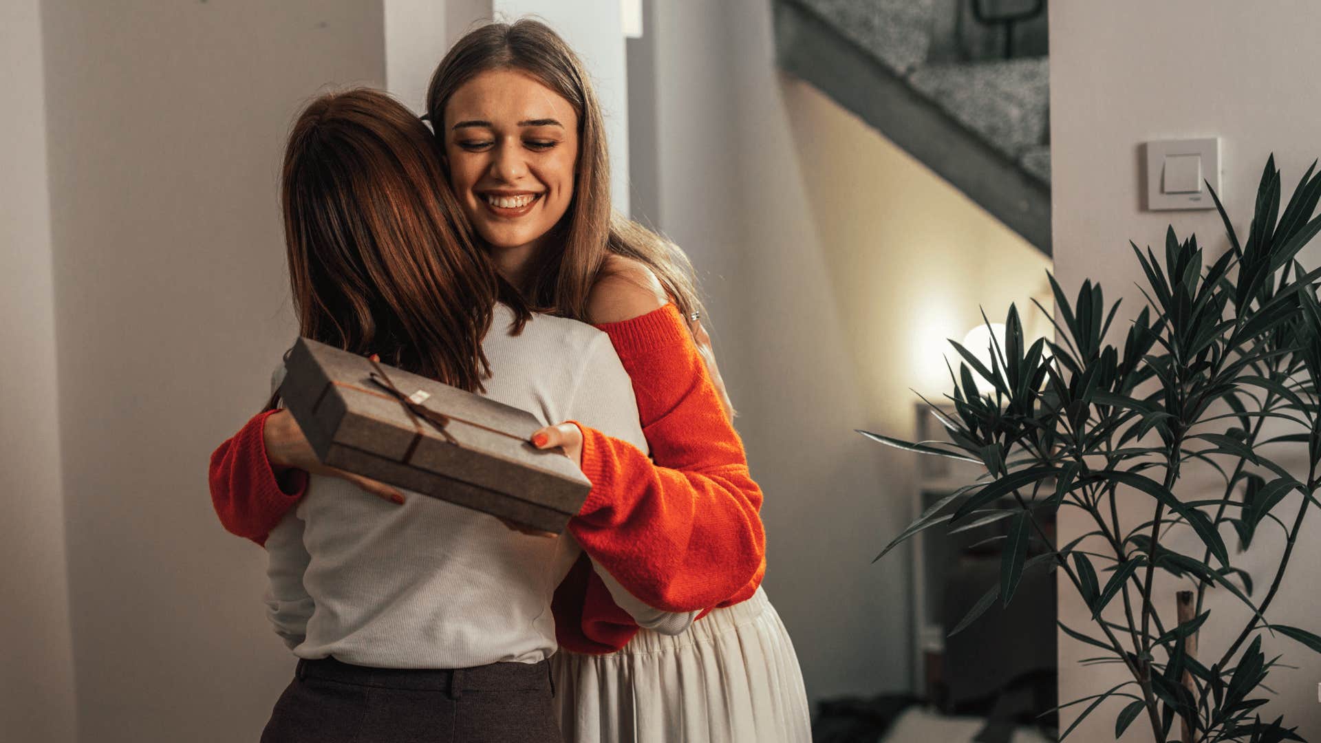 woman arriving late and hugging friend