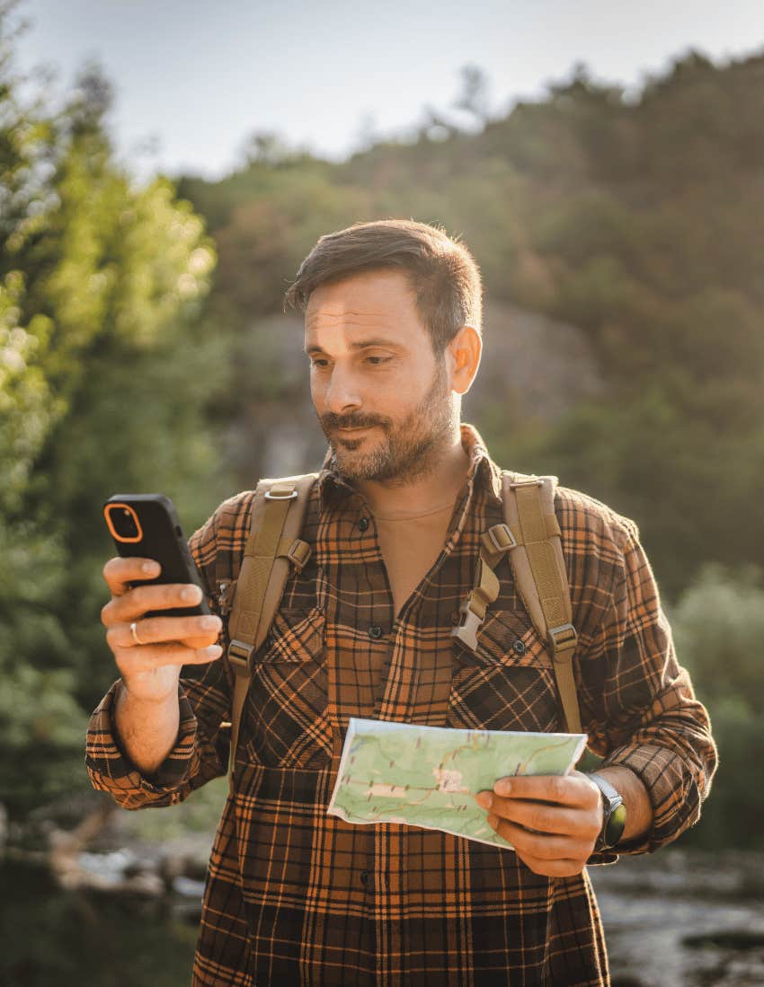 A man gives up on using his physical map to use his smartphone's GPS instead.