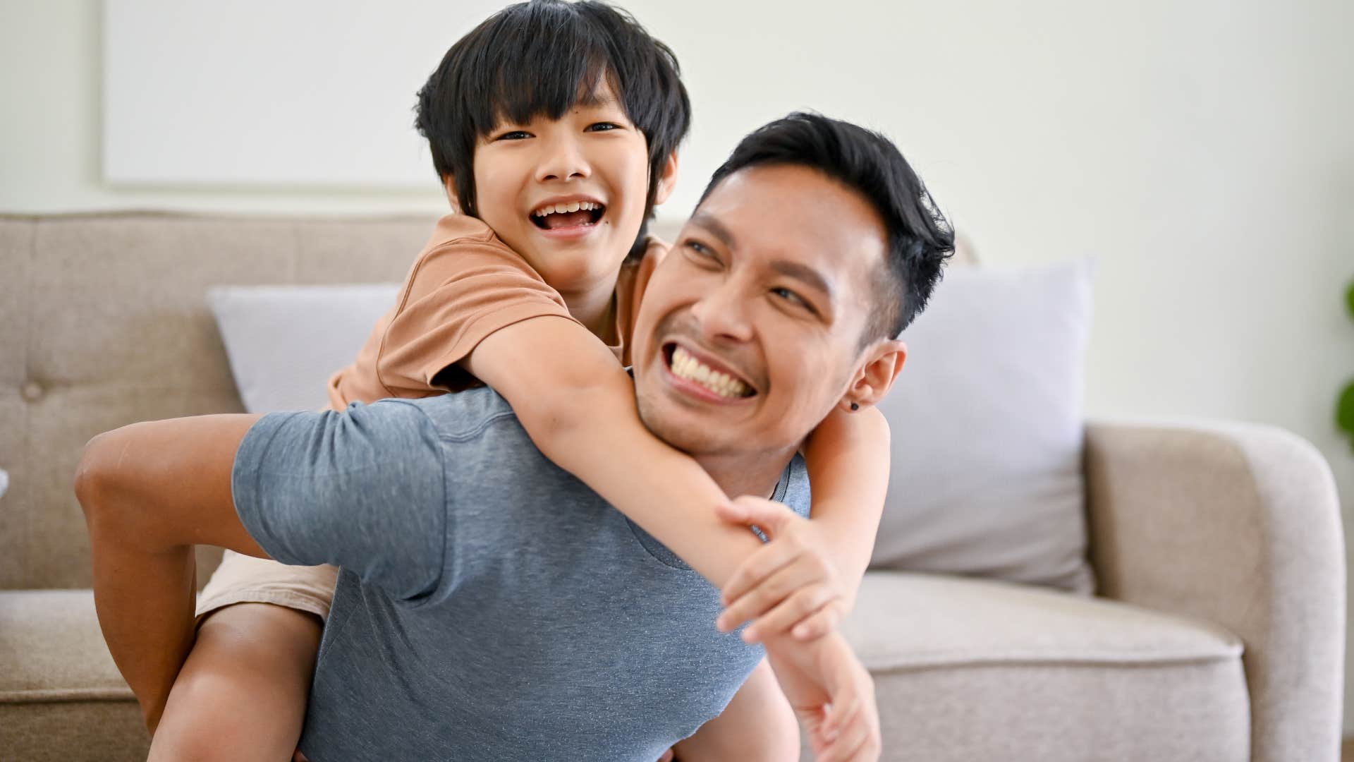 Man who knows time moves quickly smiling and hugging his son.
