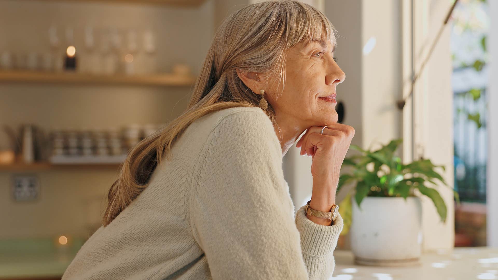 Woman who knows her opinions, beliefs, and identity will change looking out a window.