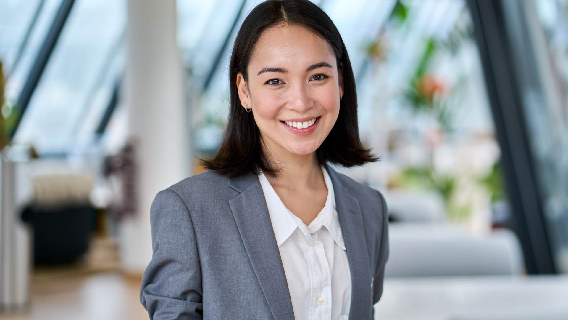 Woman who knows that work won't always be fulfilling smiling in an office.