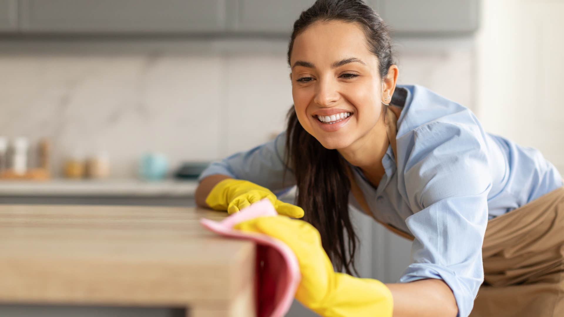 woman cleaning nonmetal furnishings in her kitchen