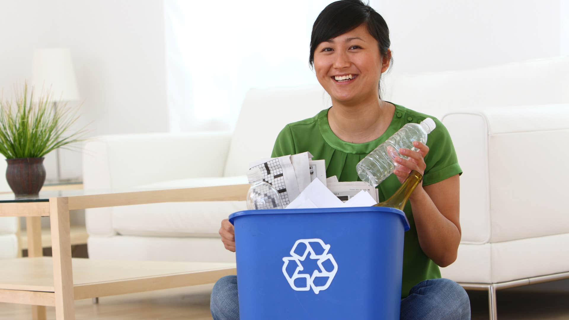 woman putting plastic bottles into trash cans without a lid