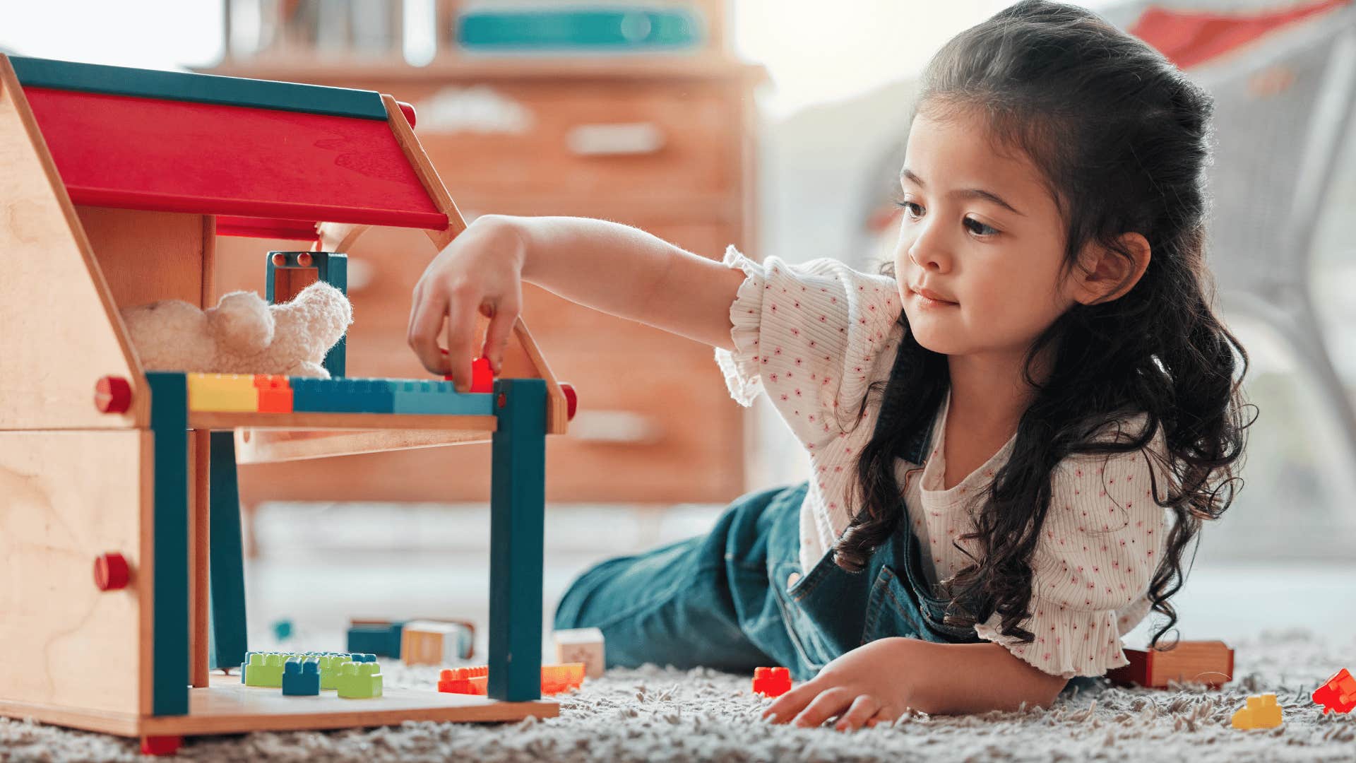 little girl playing with toy and refusing to share
