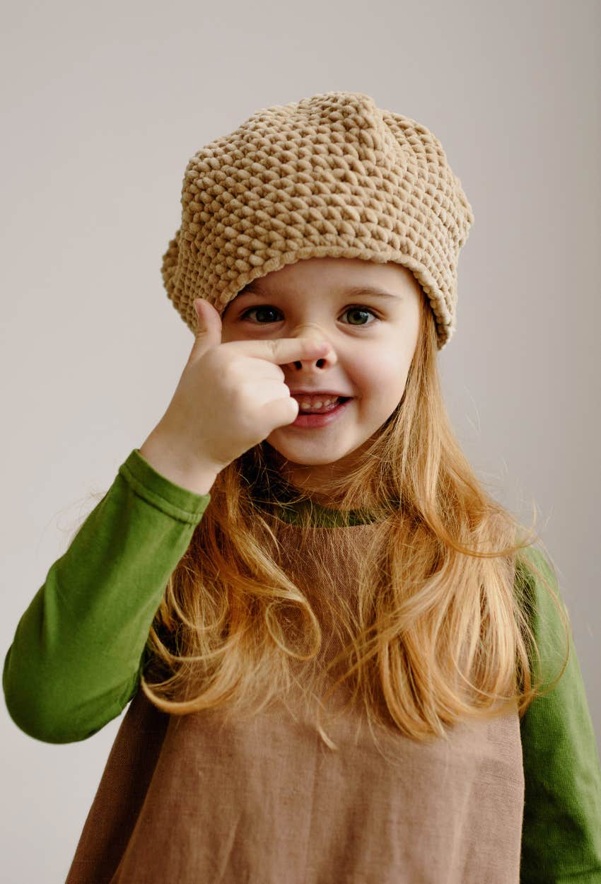 Child hiding her nose for fear that it's growing from lying