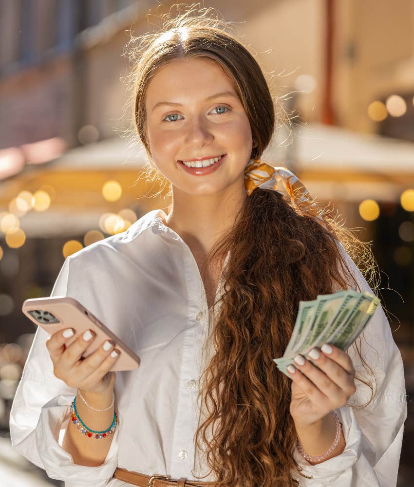 woman attracting money using her phone case