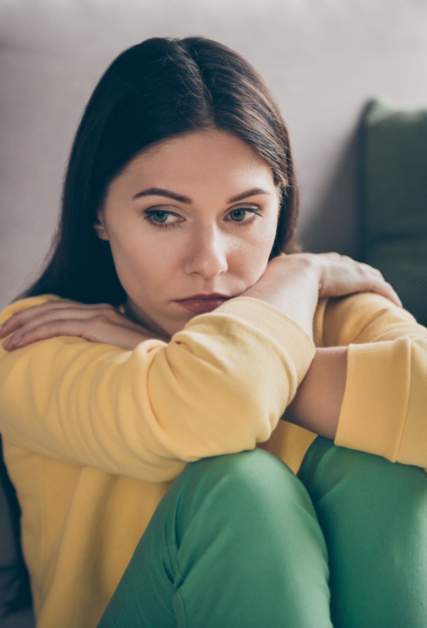 woman sitting with her arms crossed looking upset