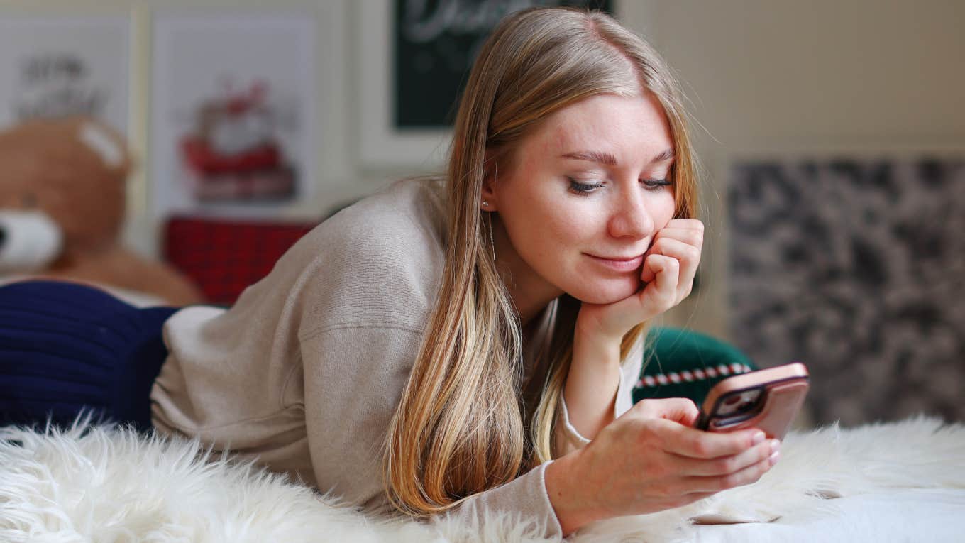 woman scrolling on phone in bed
