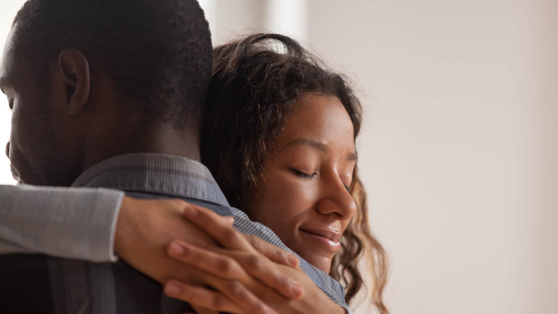 A wife hugs her husband after he kindly gives her a gift.