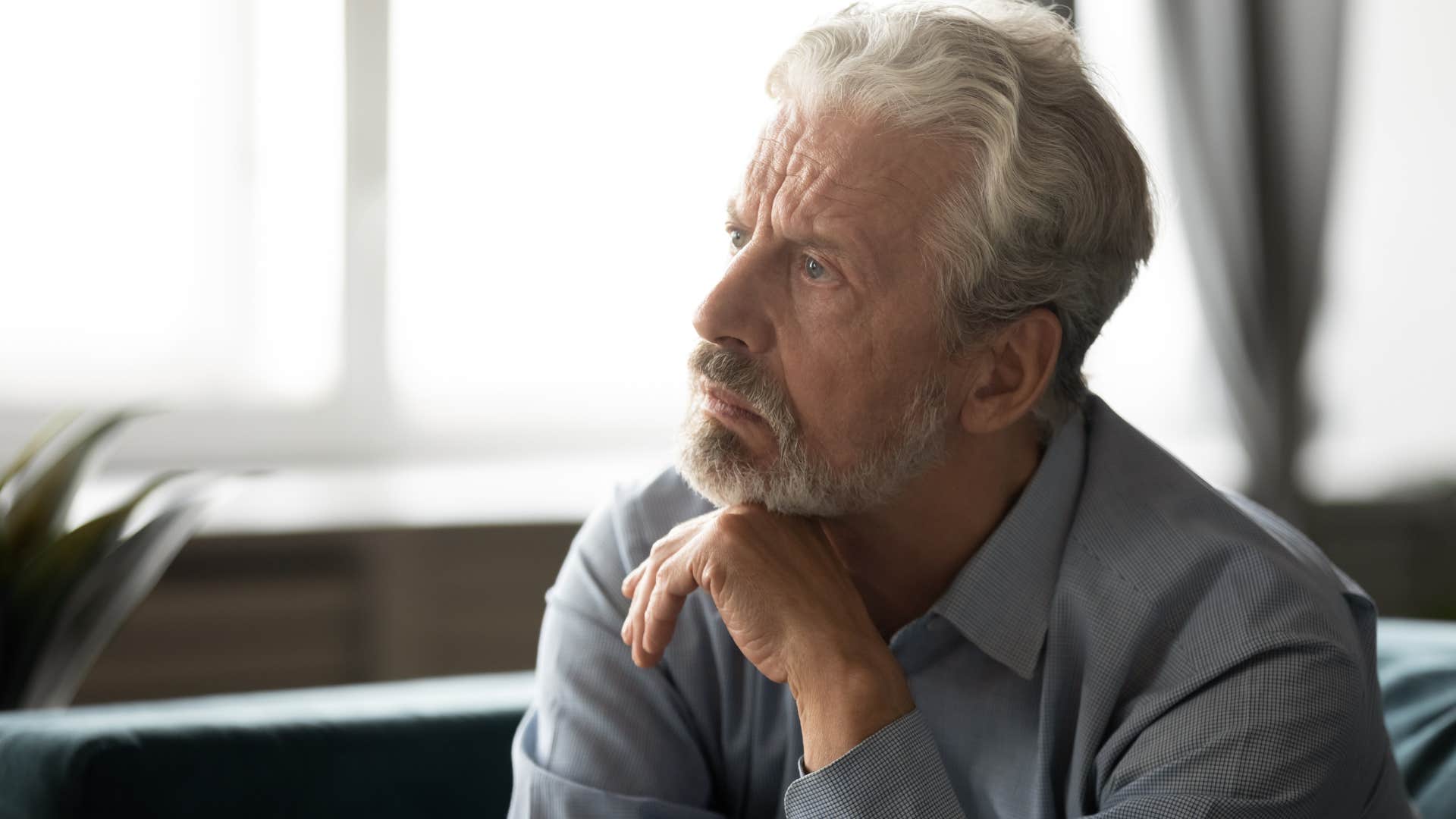Man thinking "crying doesn't fix anything" while looking away from the camera.
