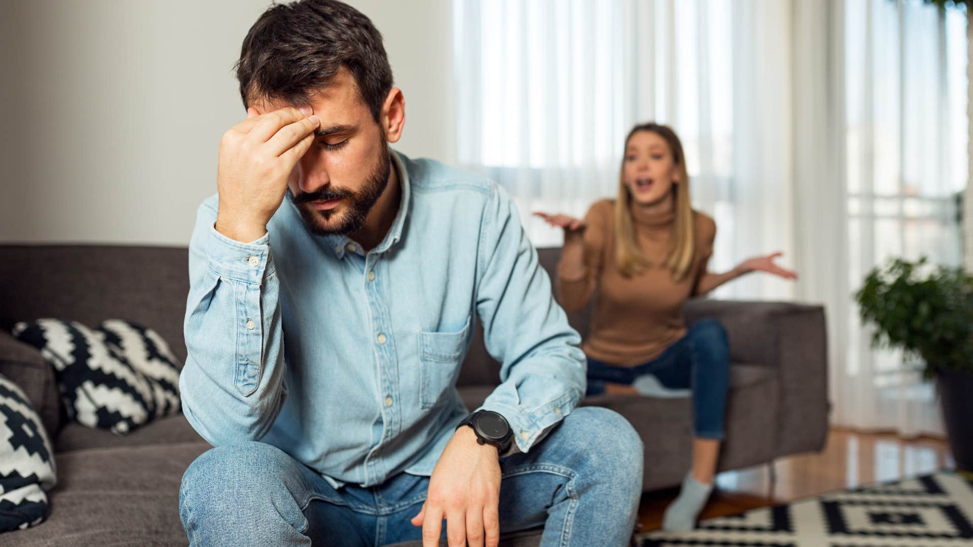 Man saying "but, i didn't mean to" while turned away from his wife.