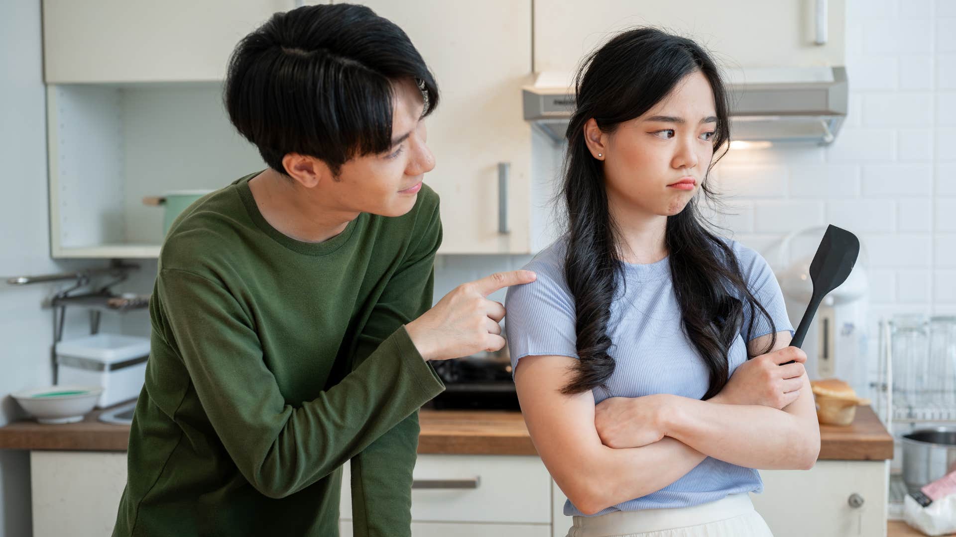 Man saying "just tell me what to do" to his wife in the kitchen.