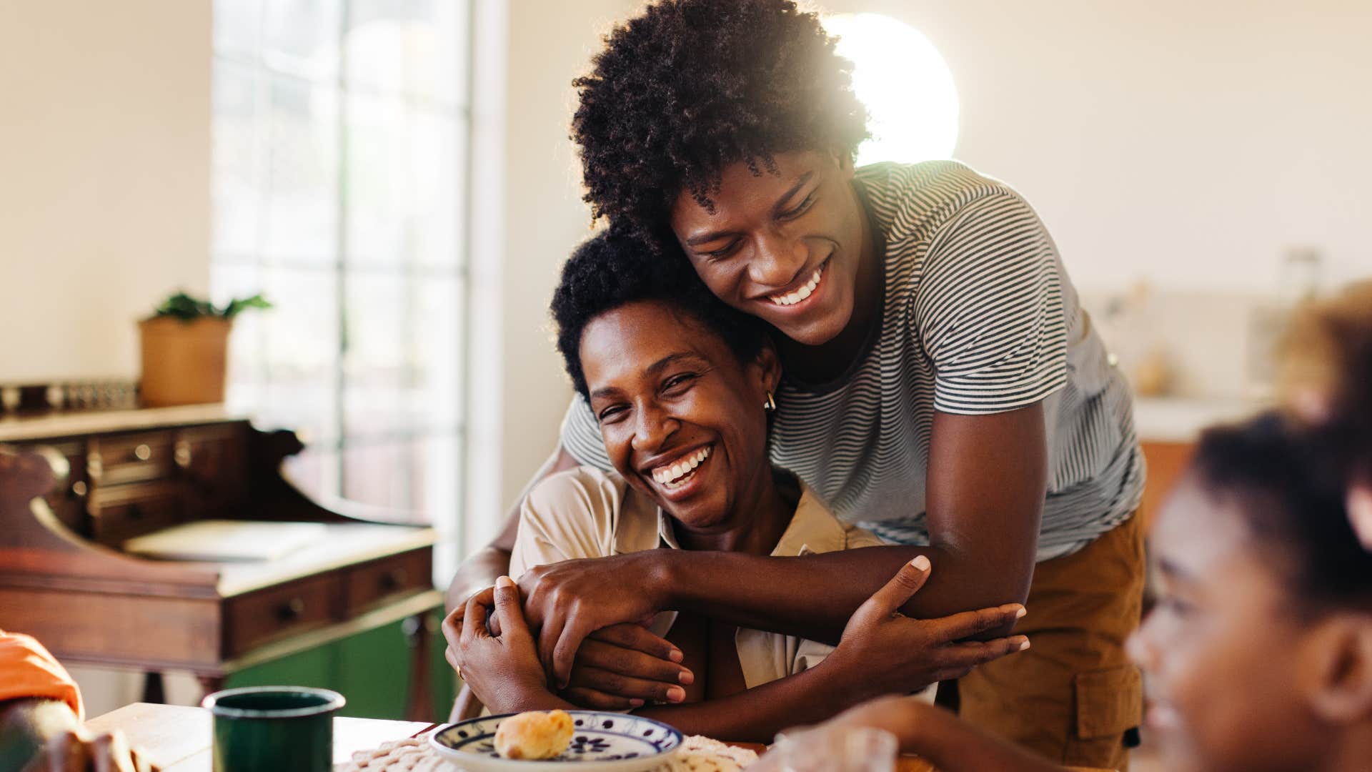 family smiling hugging during Sunday dinner