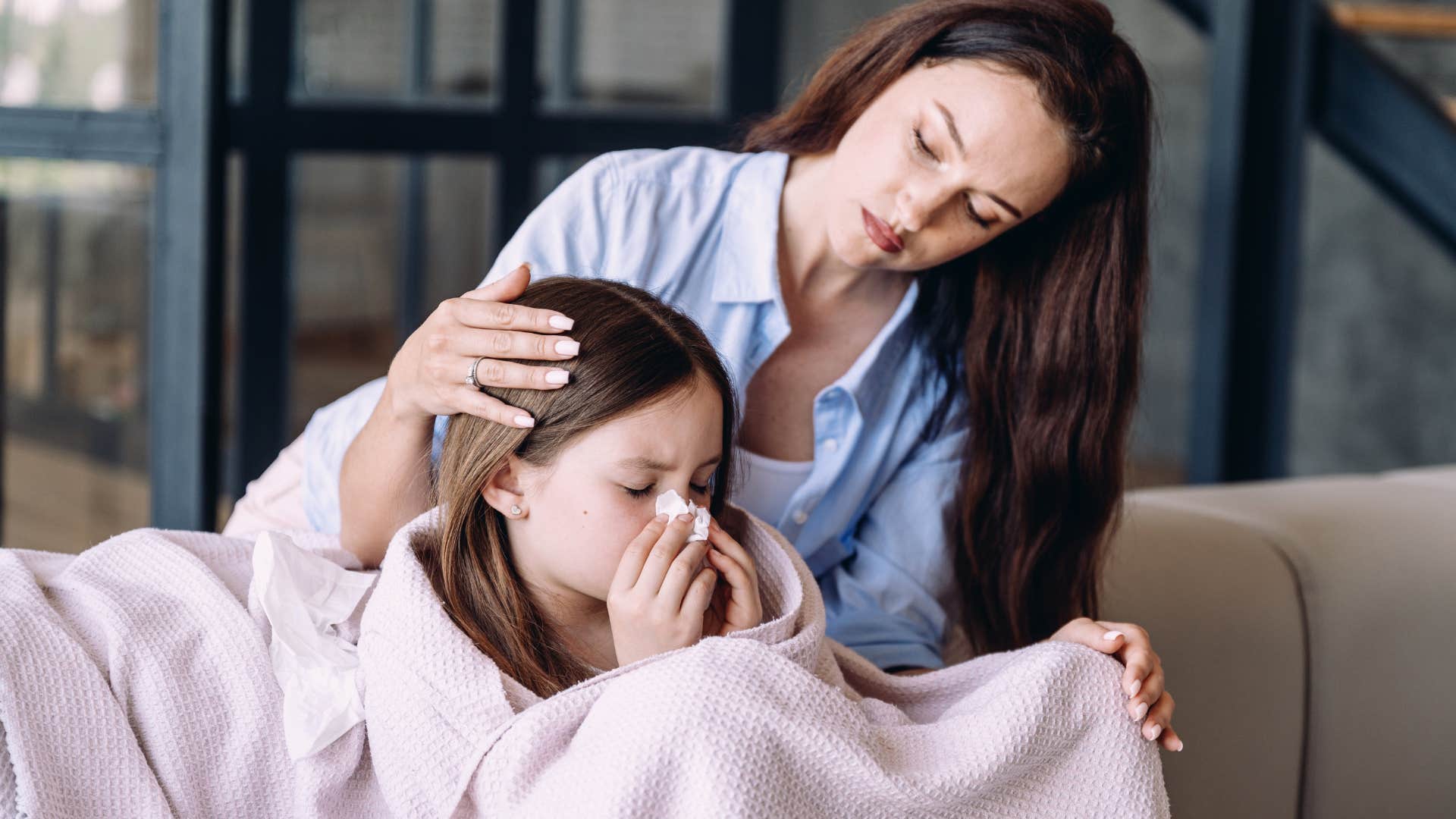 young girl taking a sick day from school being comforted by her mom