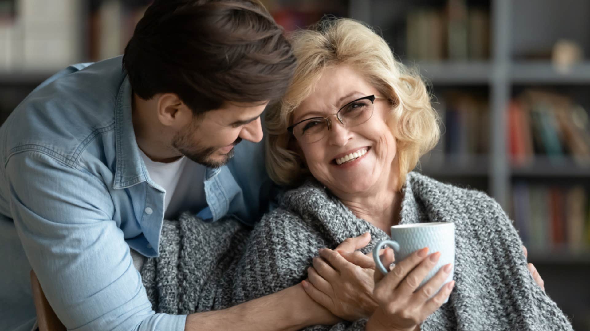 man bringing his aging mother tea taking care of her