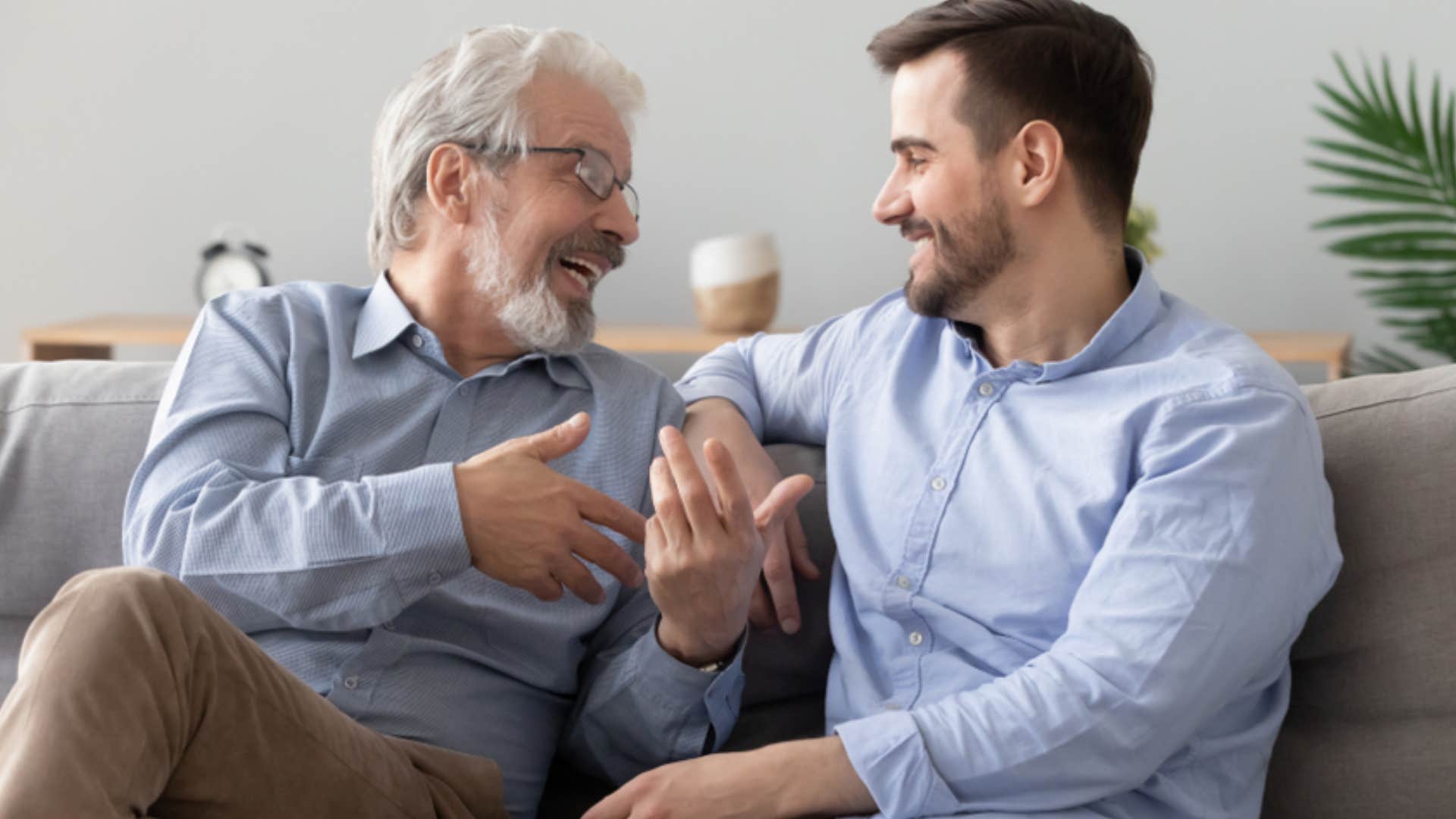 man laughing and talking with father due to family expectations 