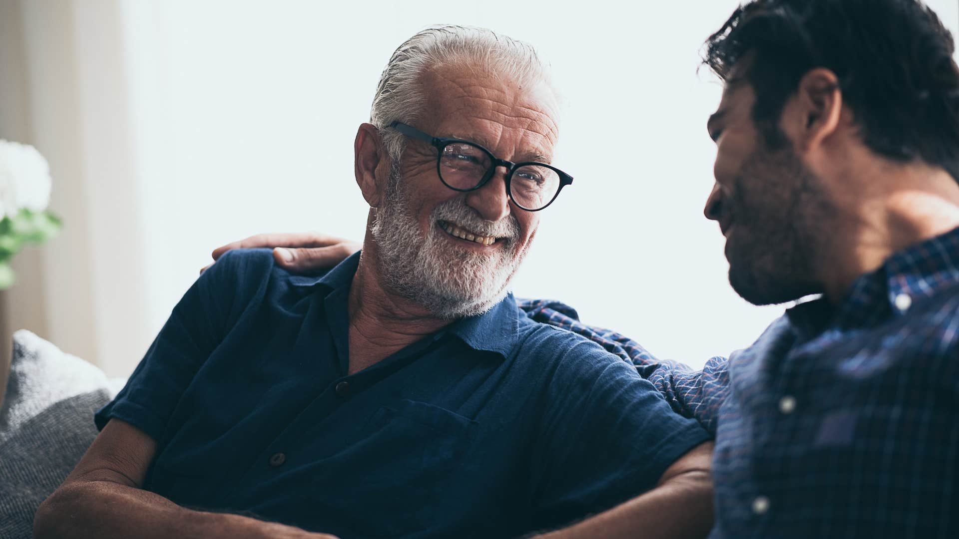 older man laughing at adult son's financial choices