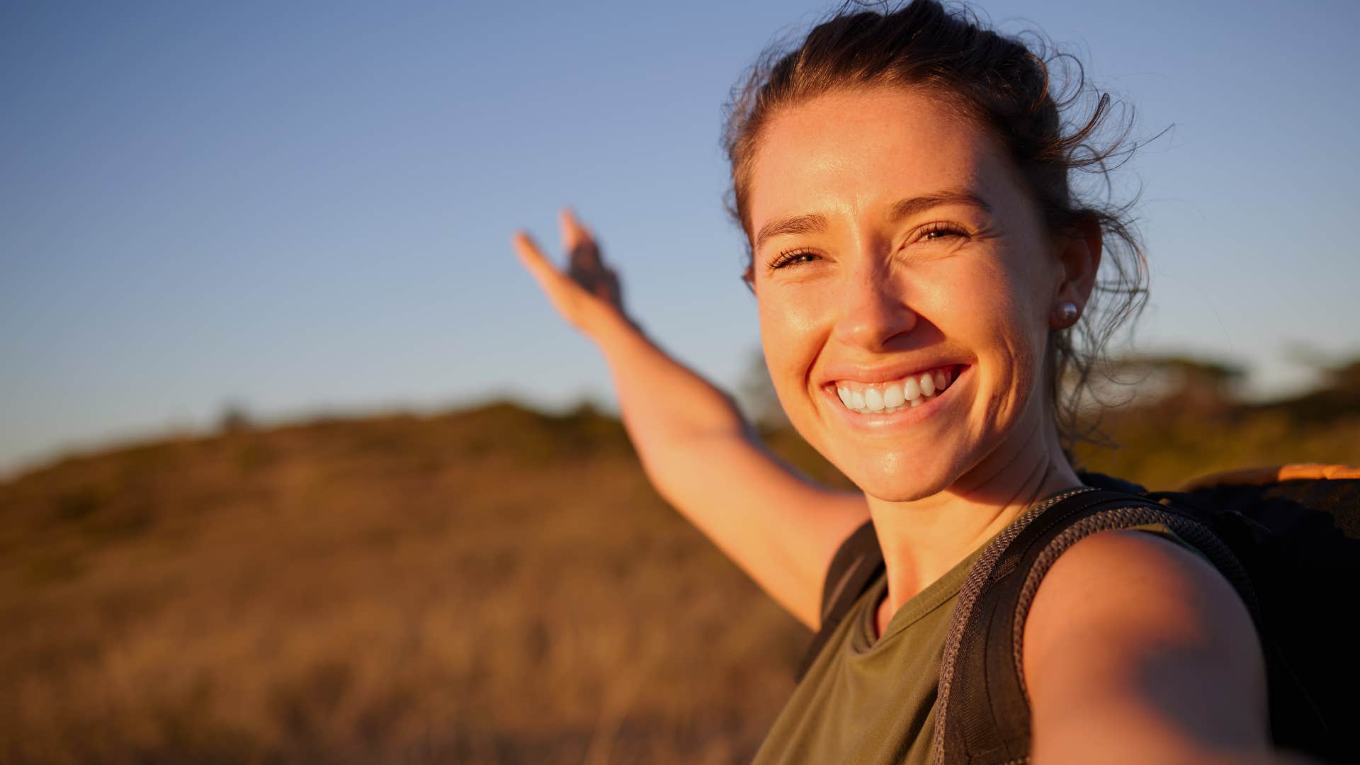 Woman who seeks purpose in life smiling outside.