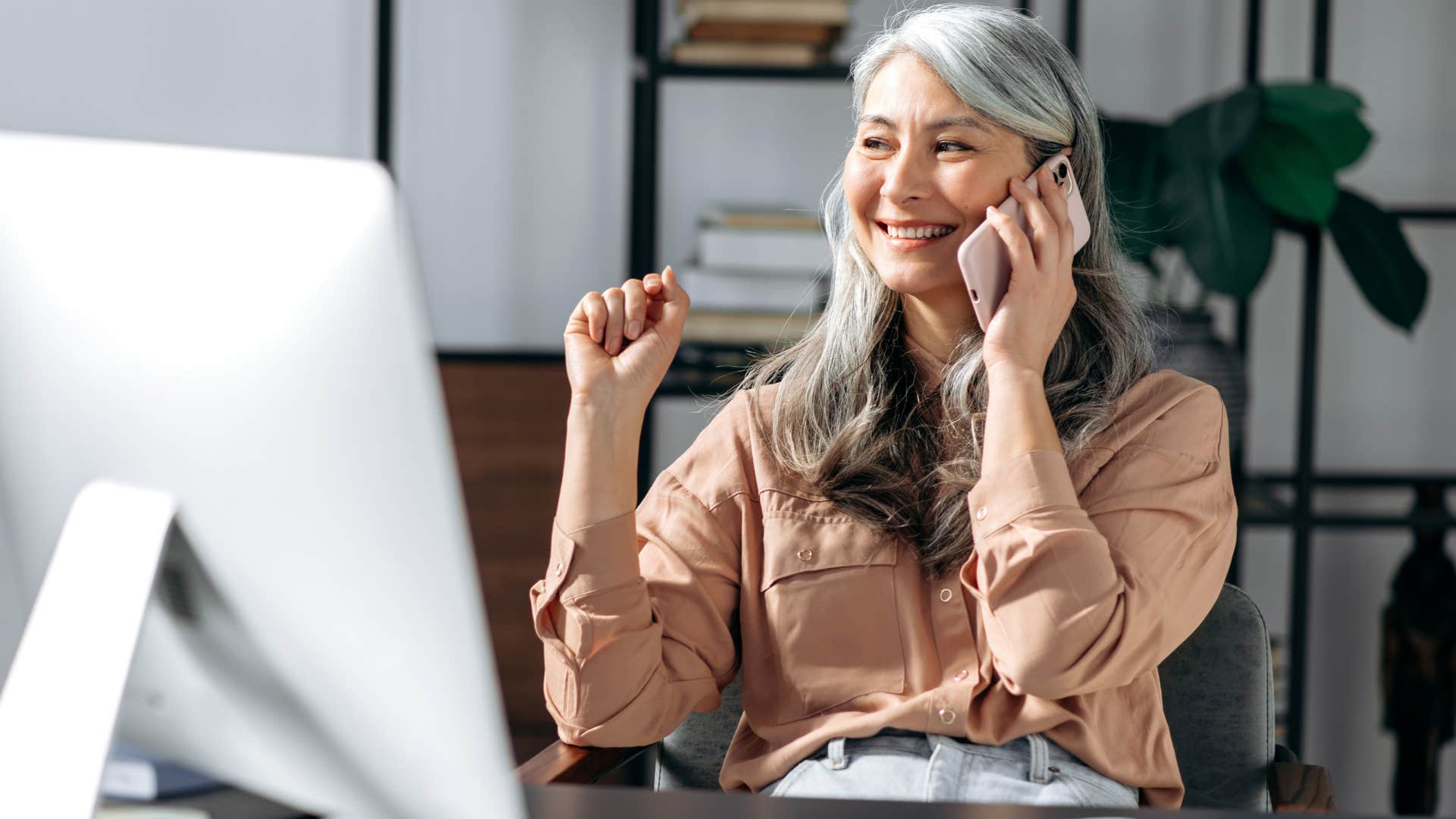 Woman who can set boundaries in the moment smiling on the phone.