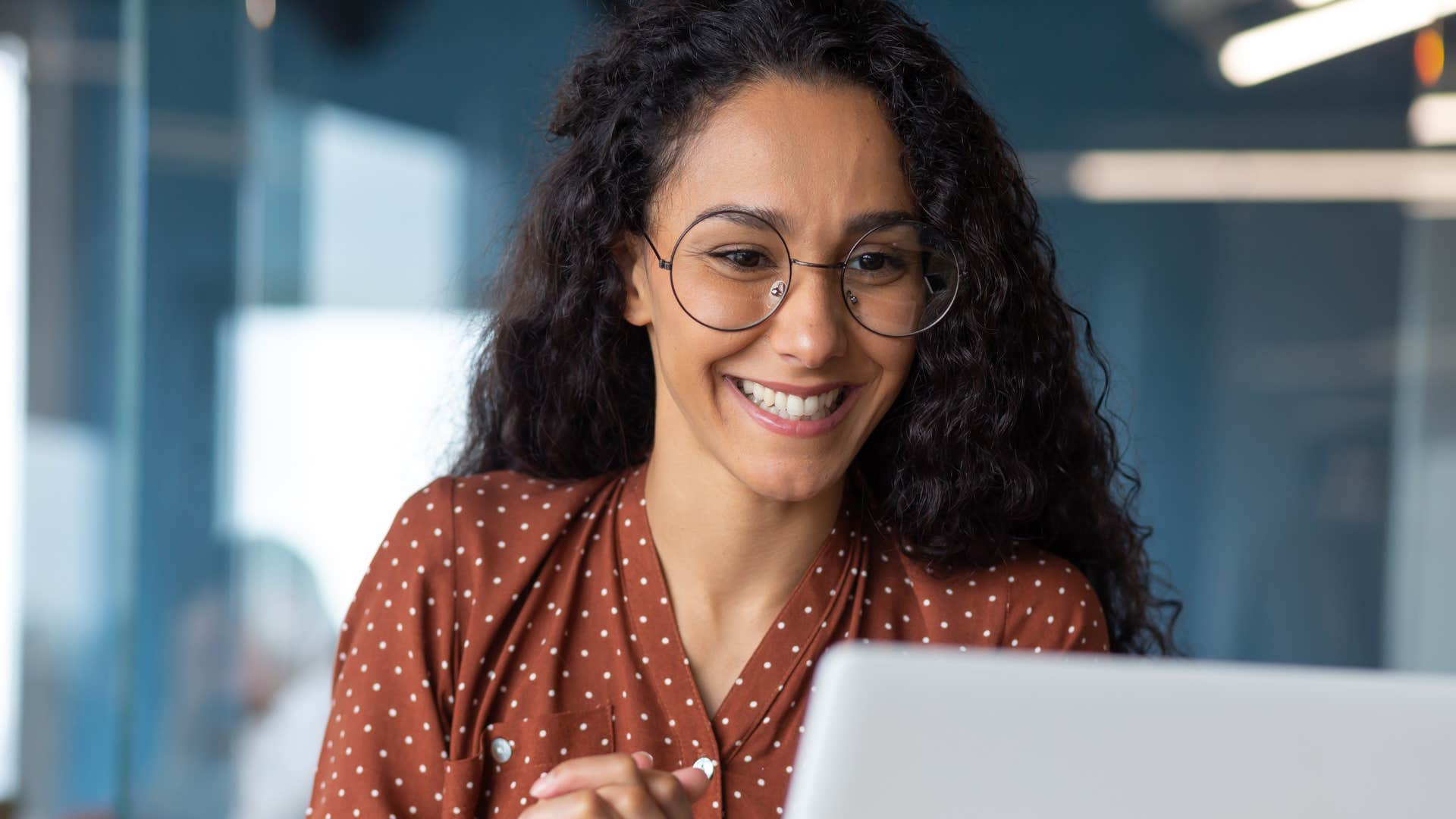 Woman who doesn't speak negatively about others smiling at work.