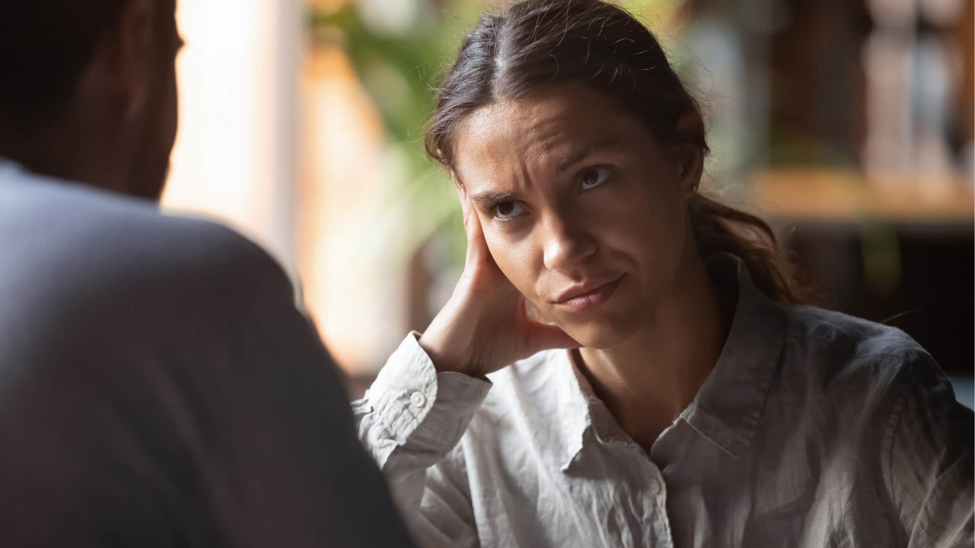 woman unable to force a smile or laugh looking at man