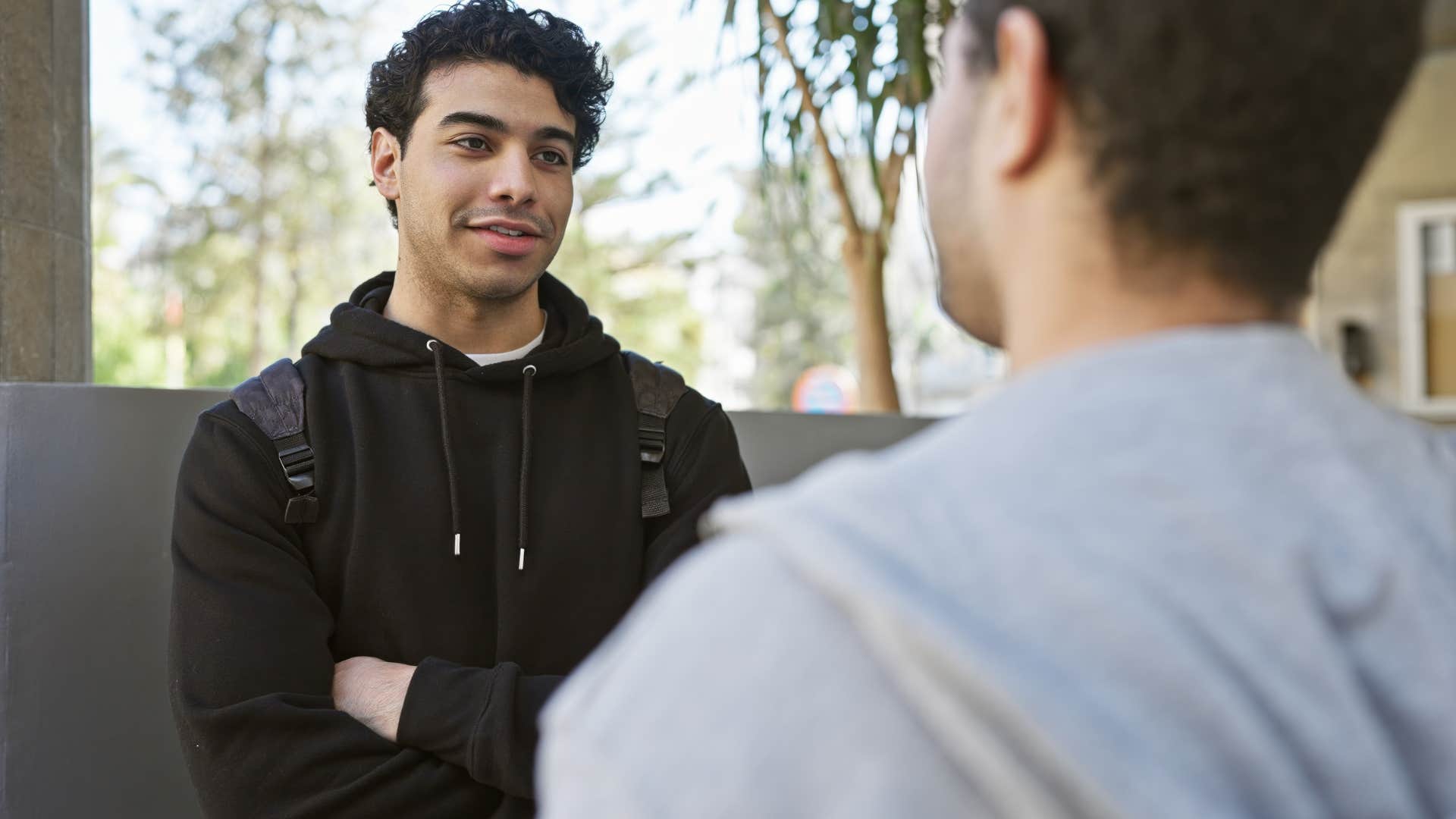 man hiding his hands having a conversation