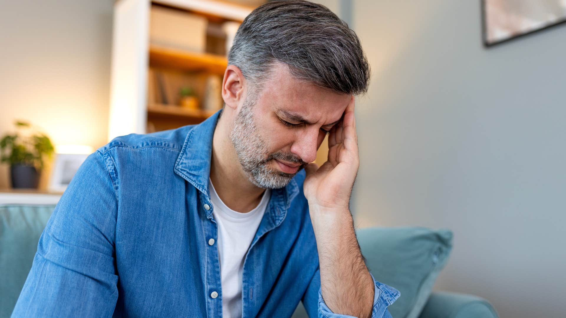 man with chronic headaches holding his head
