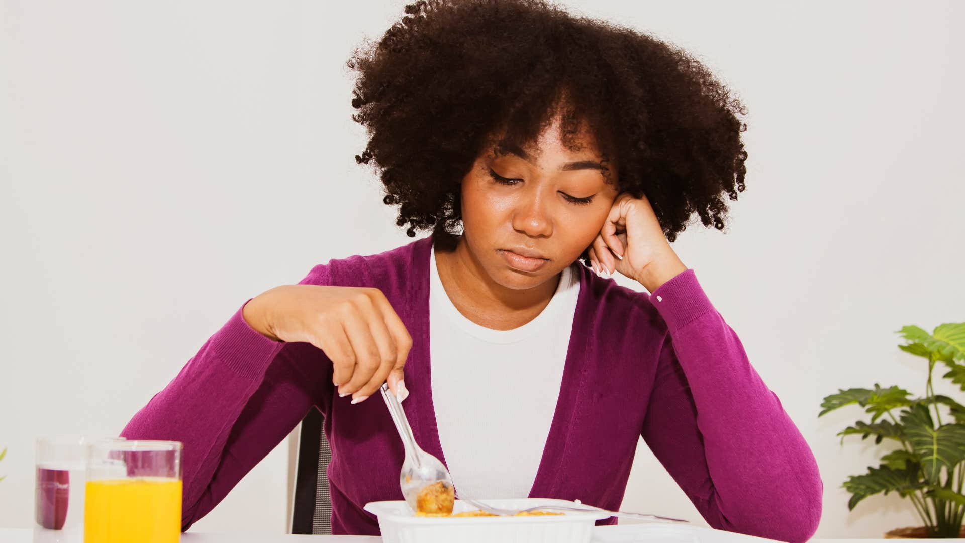 woman with no appetite dramatically looking at a plate of food