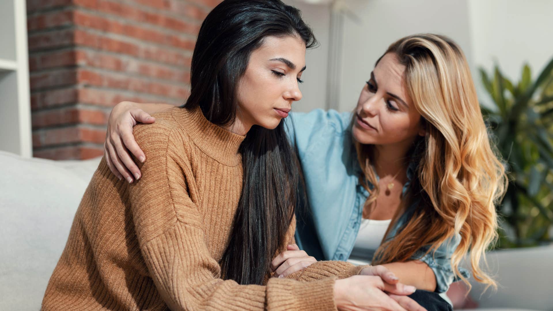 woman talking to sad friend concerned about her
